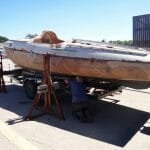 The lifting beams and jacks are called into play again to lower the boat fully onto the trailer.
