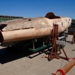 The lifting beams and jacks are called into play again to lower the boat fully onto the trailer.